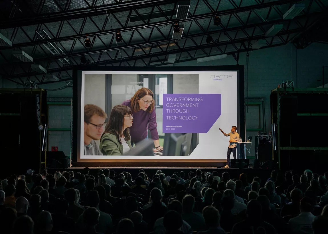 Big presentation room with presenter showing Decos slideshow